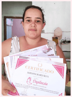 Uma mulher mostrando seu certificado de conclusão do curso de profissionalização. Ela está feliz