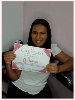 Uma mulher mostrando seu certificado de conclusão do curso de profissionalização. Ela está feliz